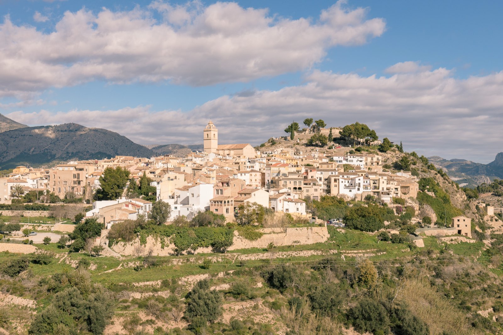 Vista de Polop de la Marina: el casco antiguo sobre el cerro, con la torre de la iglesia y el castillo